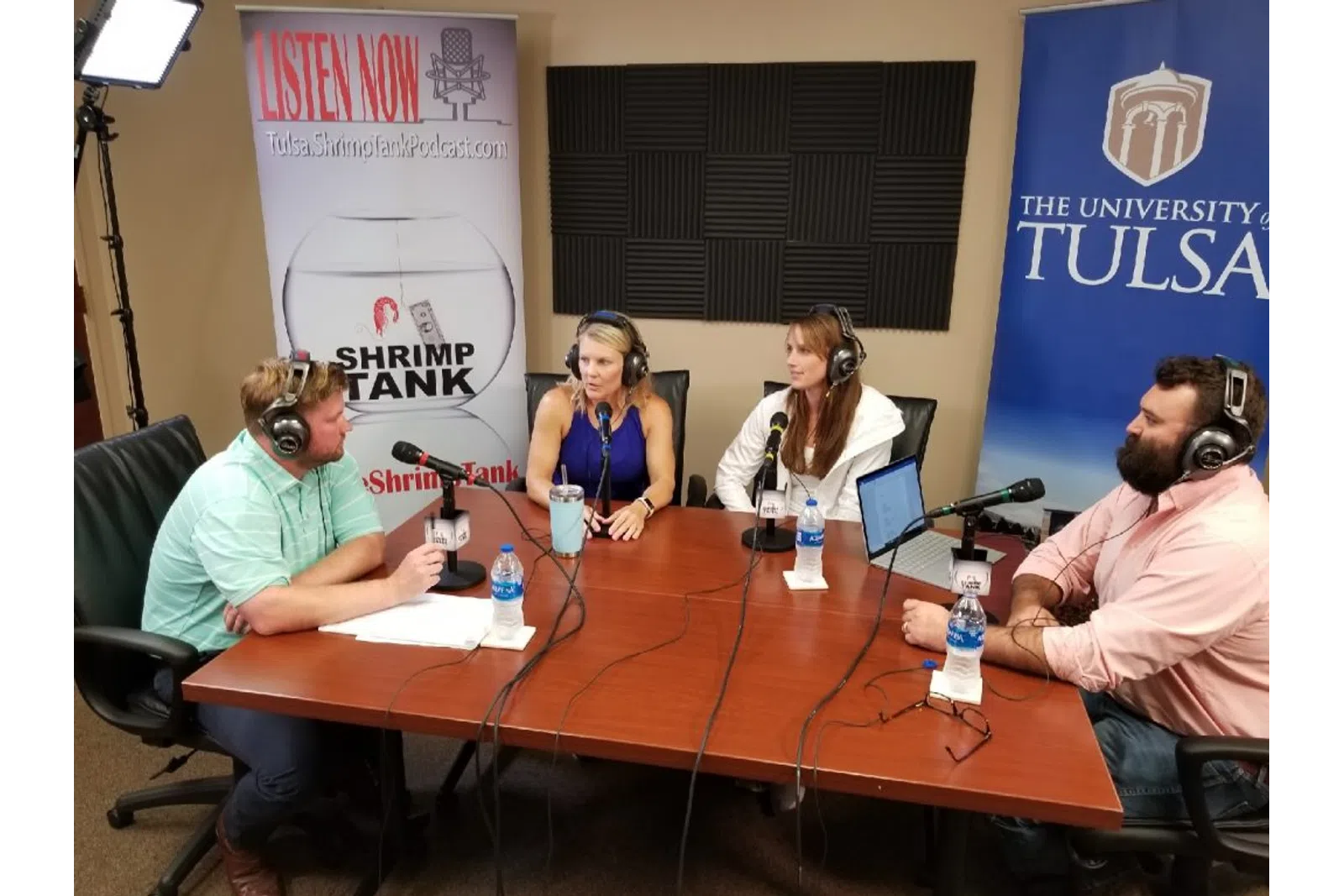 a group of people sitting around a table with microphones