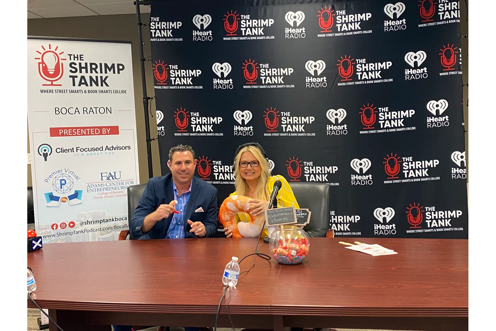 a man and woman sitting at a table with microphones