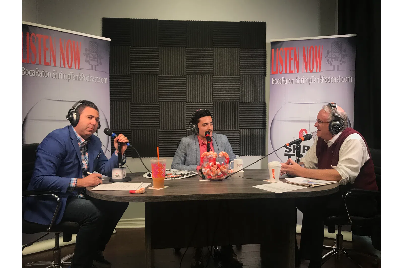a group of people sitting at a table with microphones