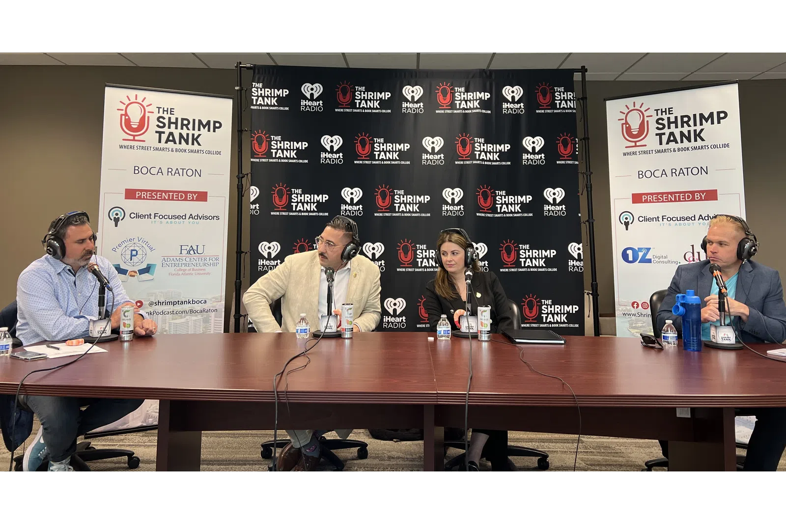 a group of people sitting at a table with microphones