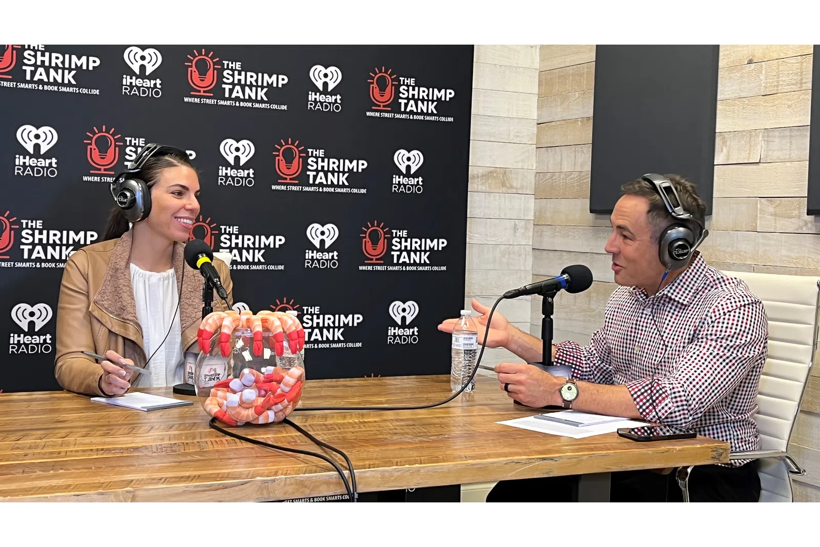 a man and woman sitting at a table with microphones
