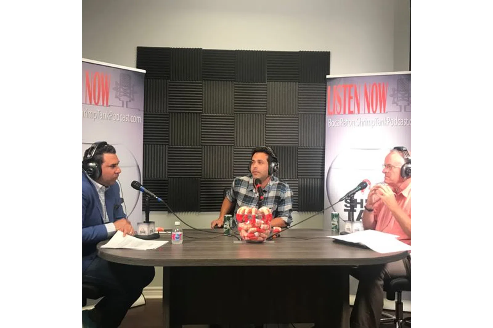 a group of people sitting at a table with microphones
