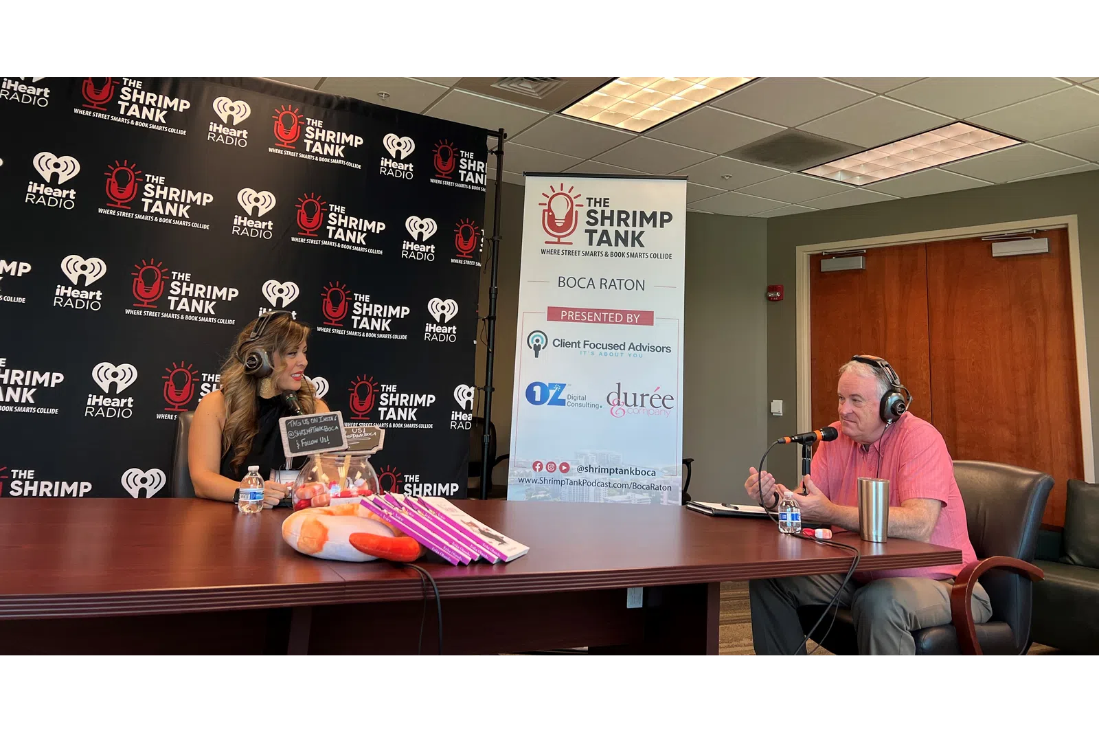 a man and a woman sitting at a table with microphones
