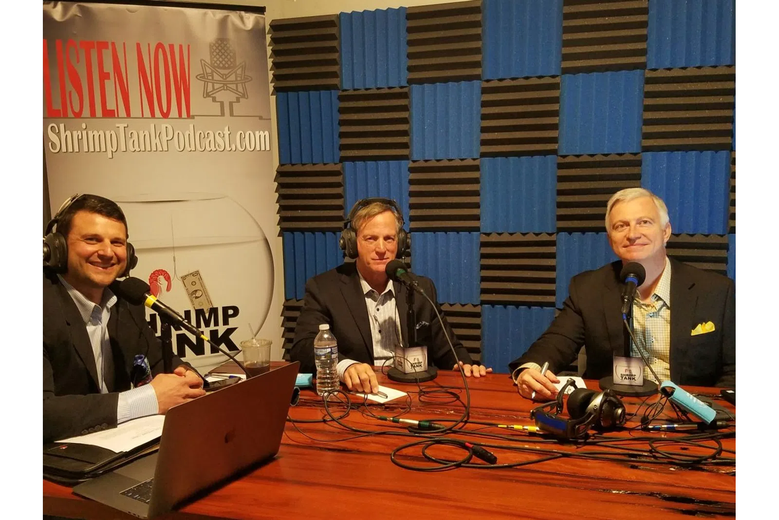 a group of men sitting at a table with microphones