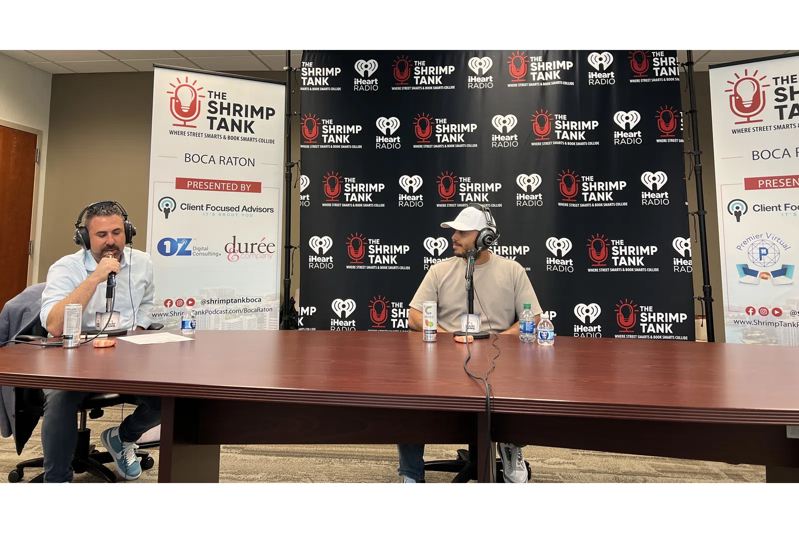 a couple of men sitting at a table with microphones and signs