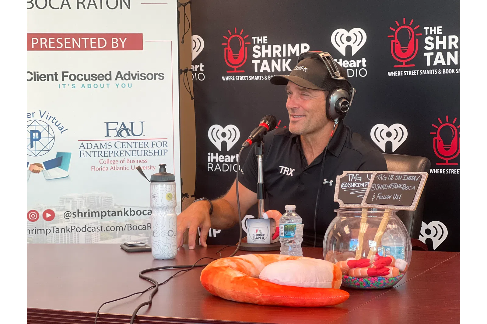 a person wearing headphones and sitting at a table with a microphone