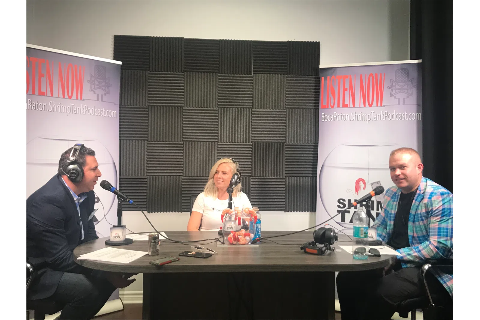 a group of people sitting at a table with microphones
