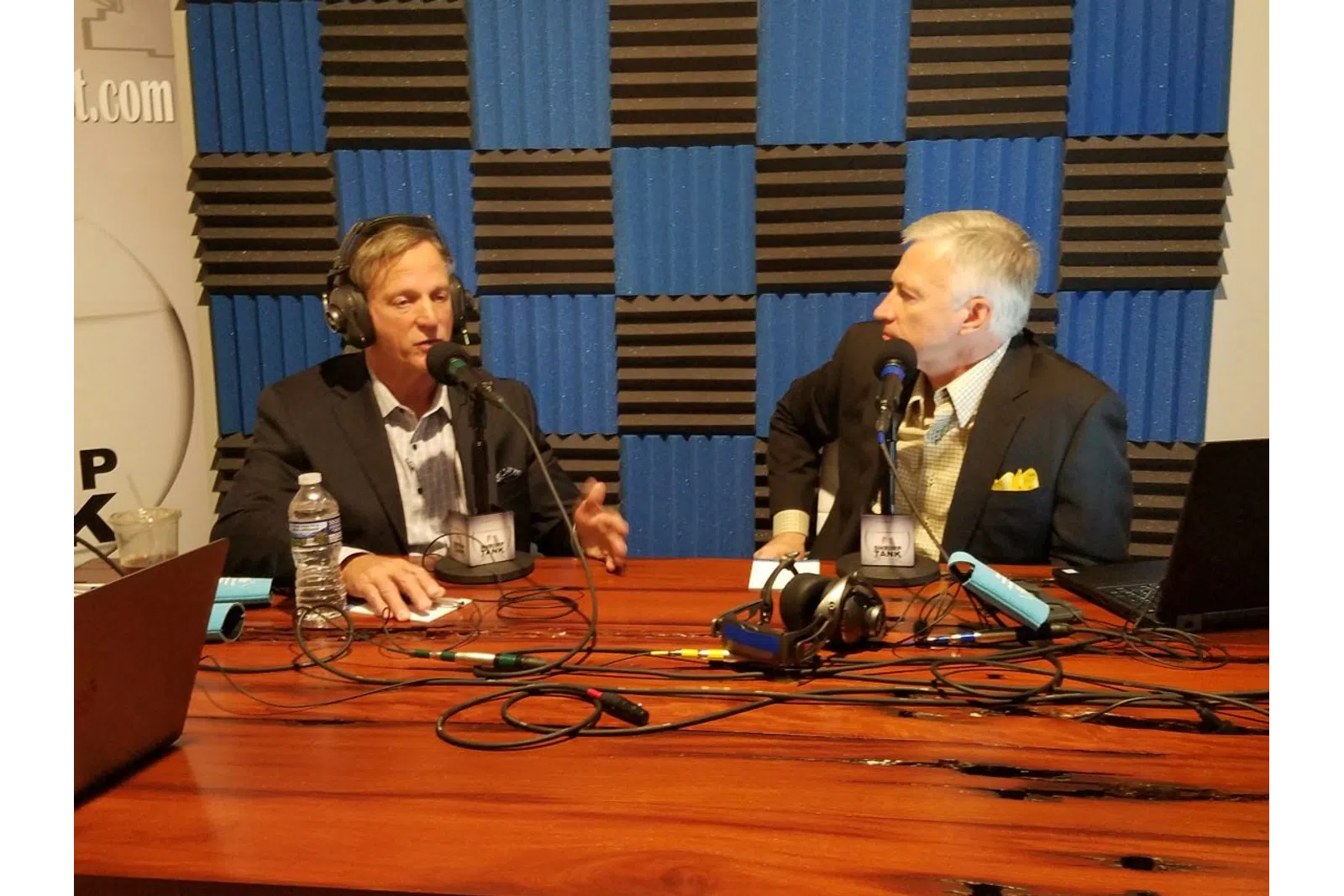 a man and a woman sitting at a table with microphones