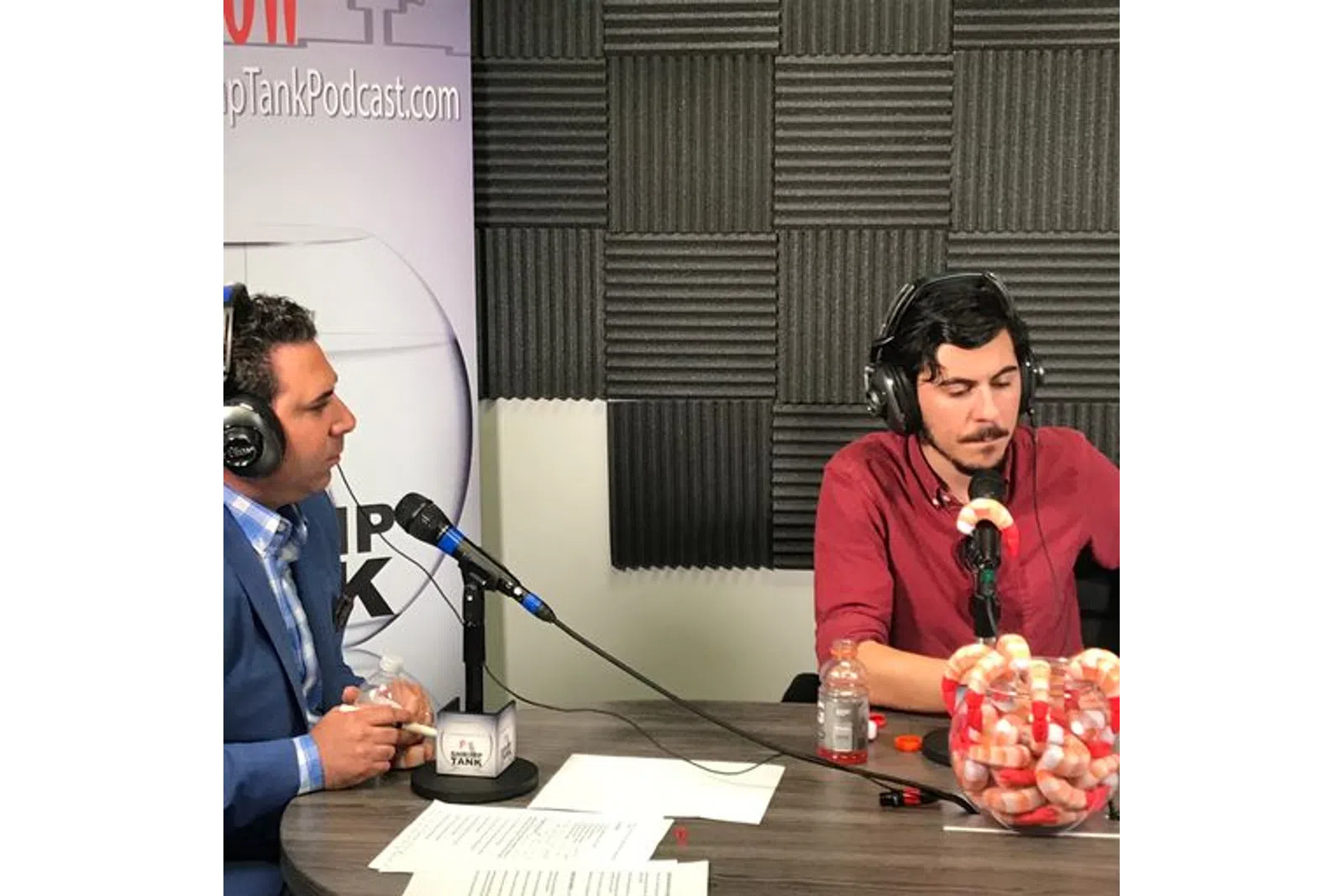 a man wearing headphones and sitting at a table with a microphone