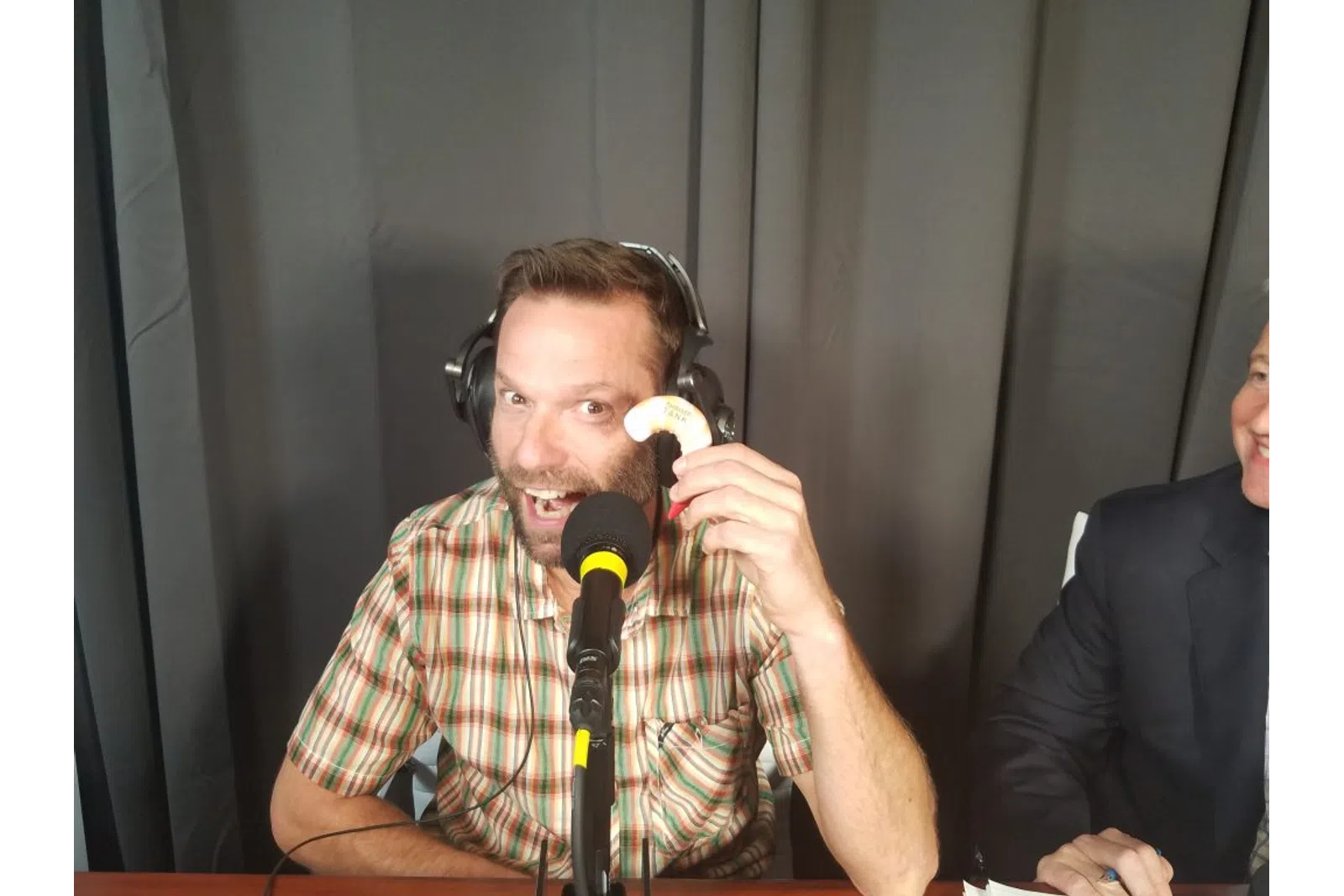 a man wearing headphones and sitting at a microphone