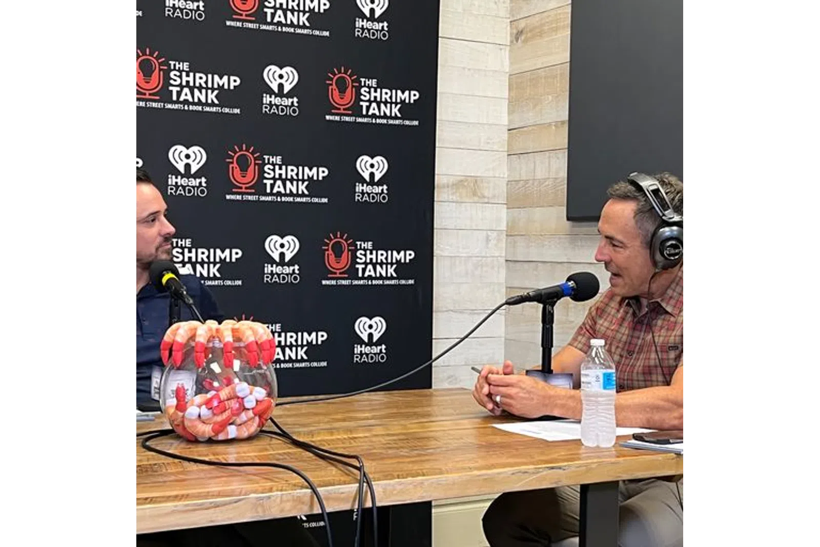 a person wearing headphones and sitting at a table with a microphone