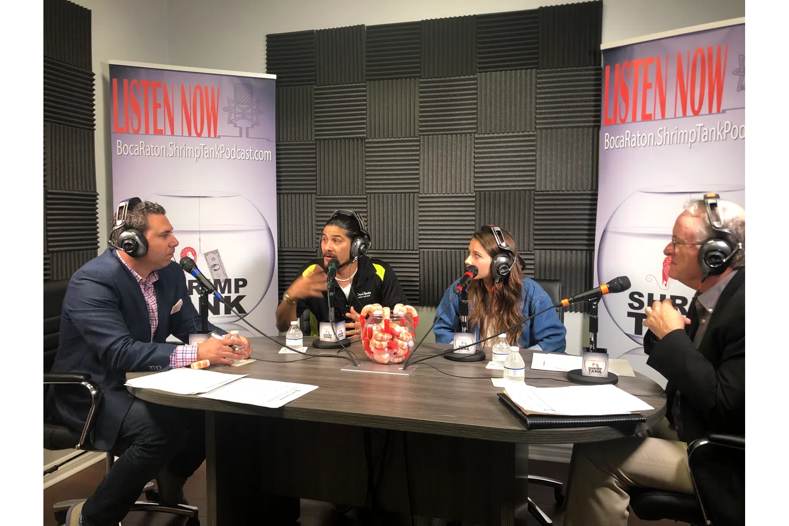 a group of people sitting at a table with microphones