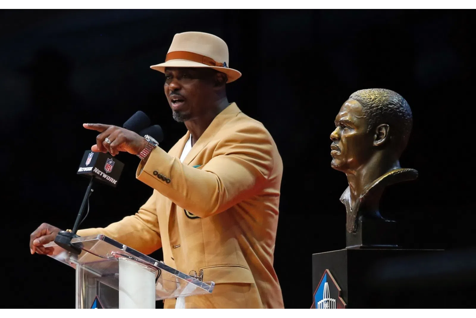 Brian Dawkins with a microphone pointing at another man
