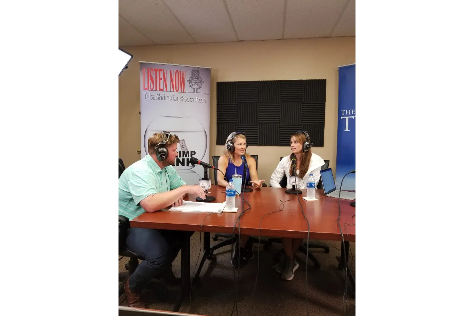 a group of people sitting at a table with microphones