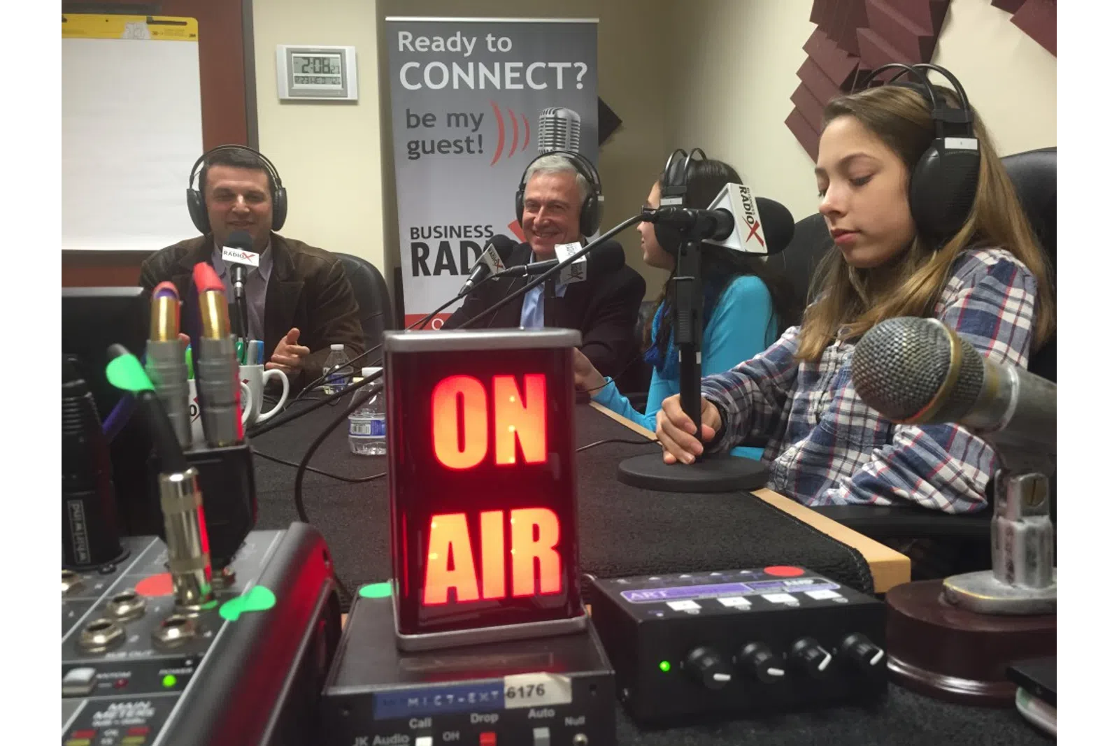 a group of people sitting at a table with microphones