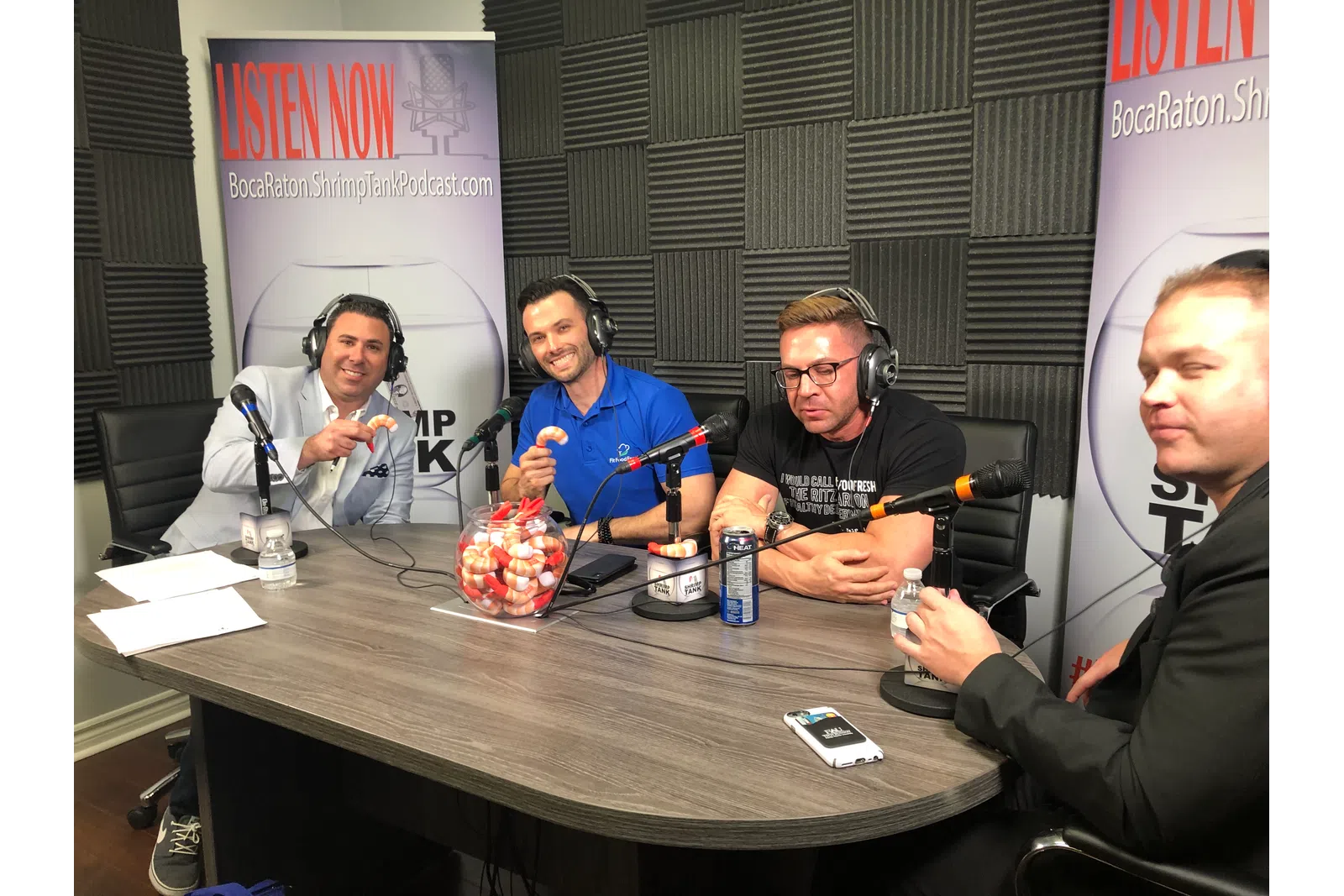 a group of people sitting at a table with microphones