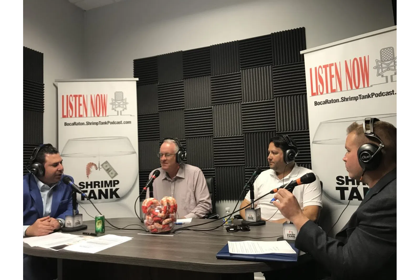 a group of people sitting at a table with microphones