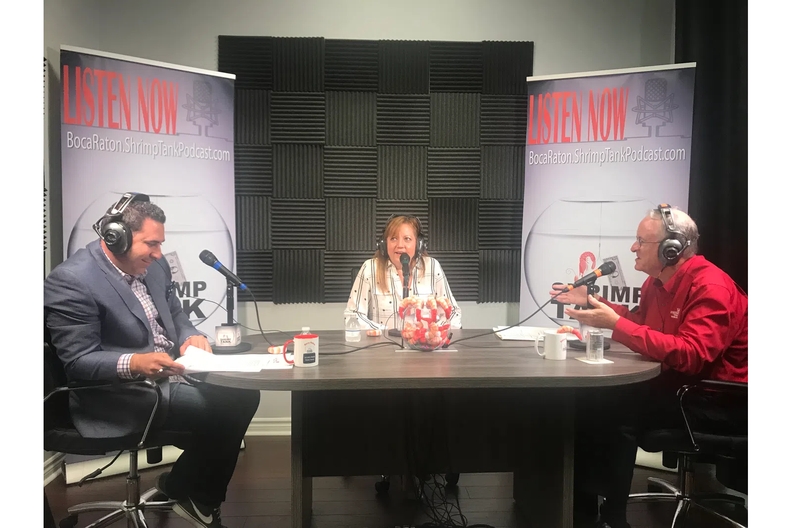 a group of people sitting at a table with microphones