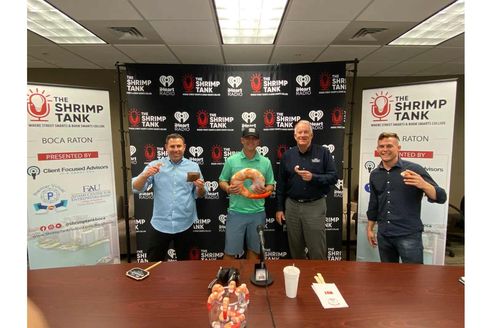 a group of men standing in front of a table with a sign
