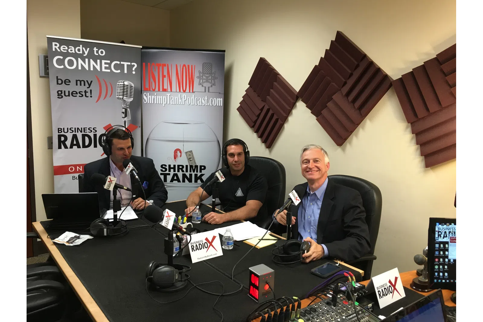 a group of men sitting at a table with microphones