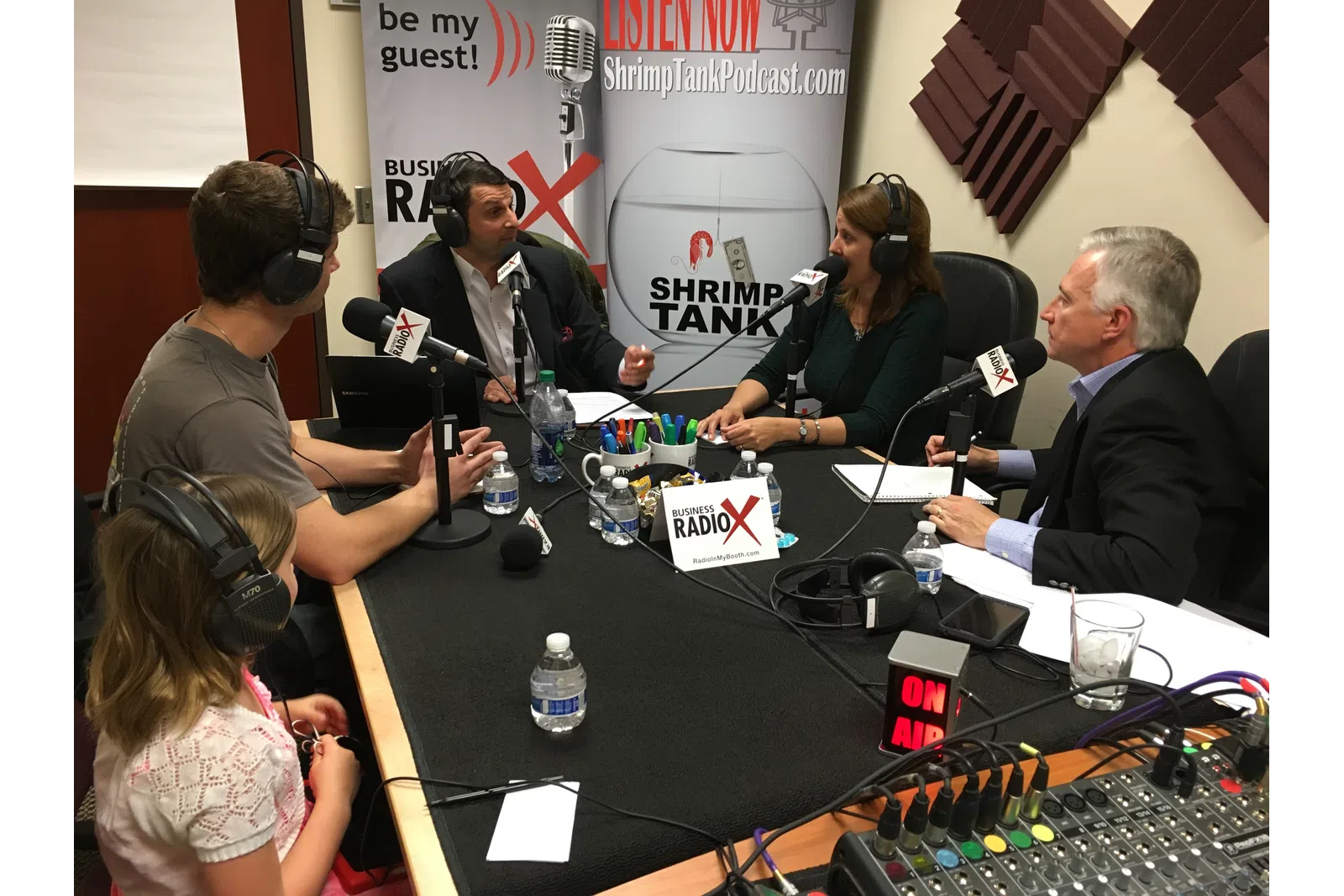 a group of people sitting at a table with microphones
