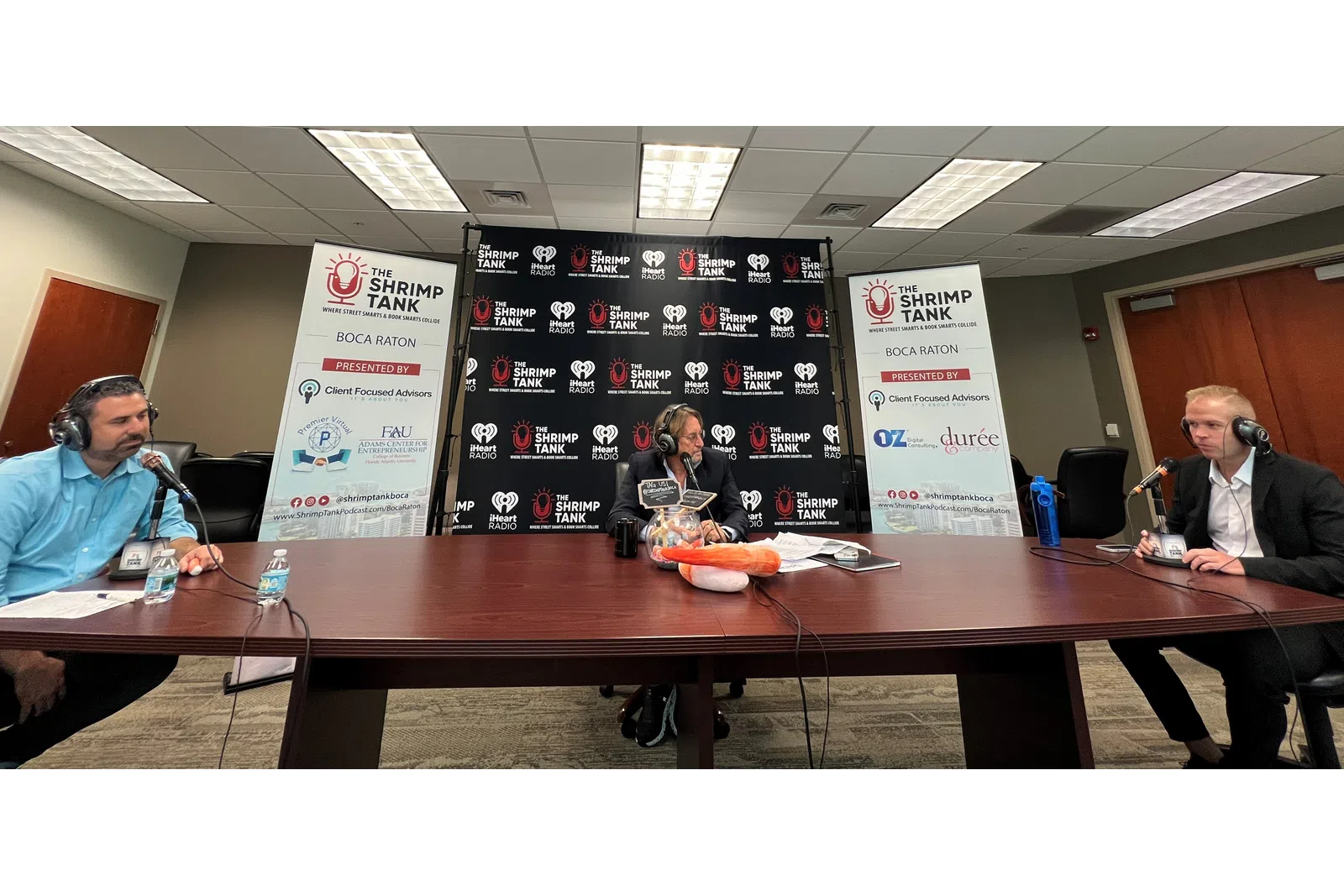 a group of people sitting at a table with microphones