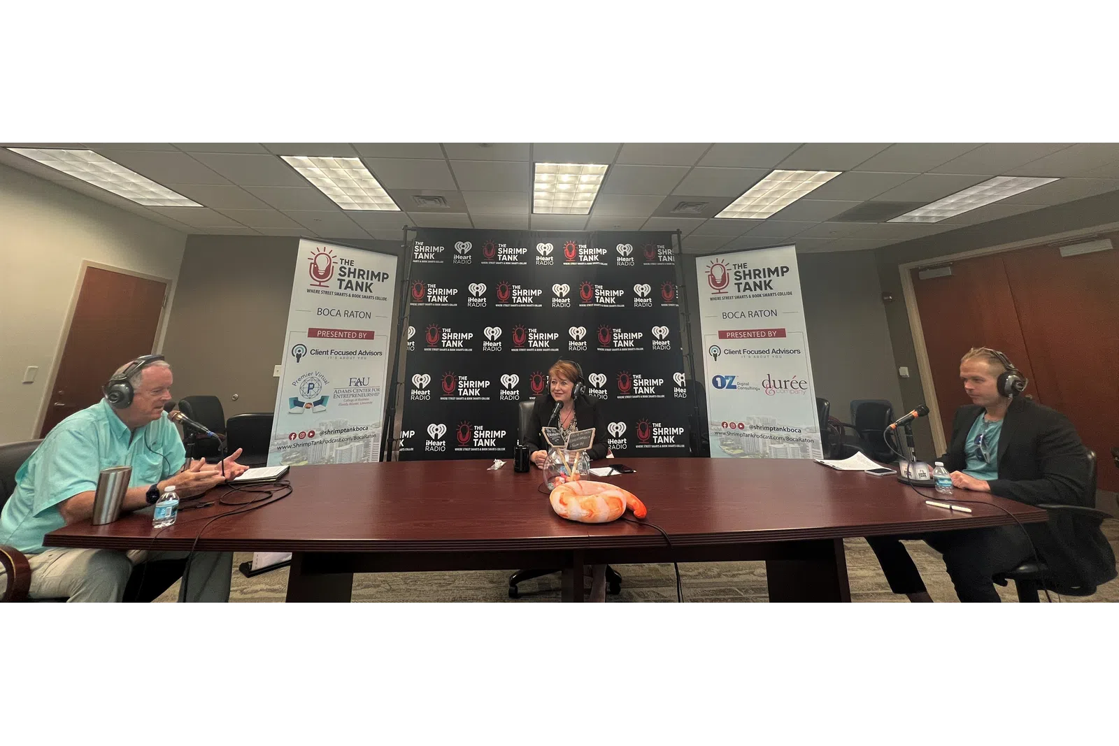 a group of people sitting at a table with microphones
