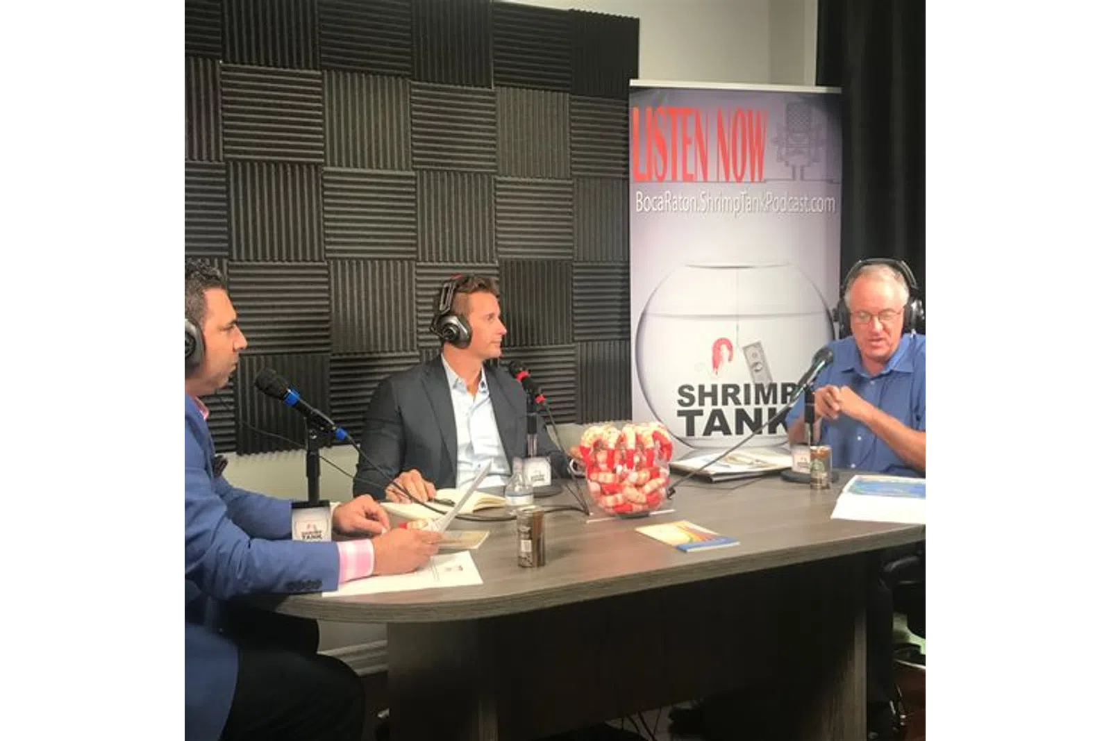 a group of people sitting at a table with microphones