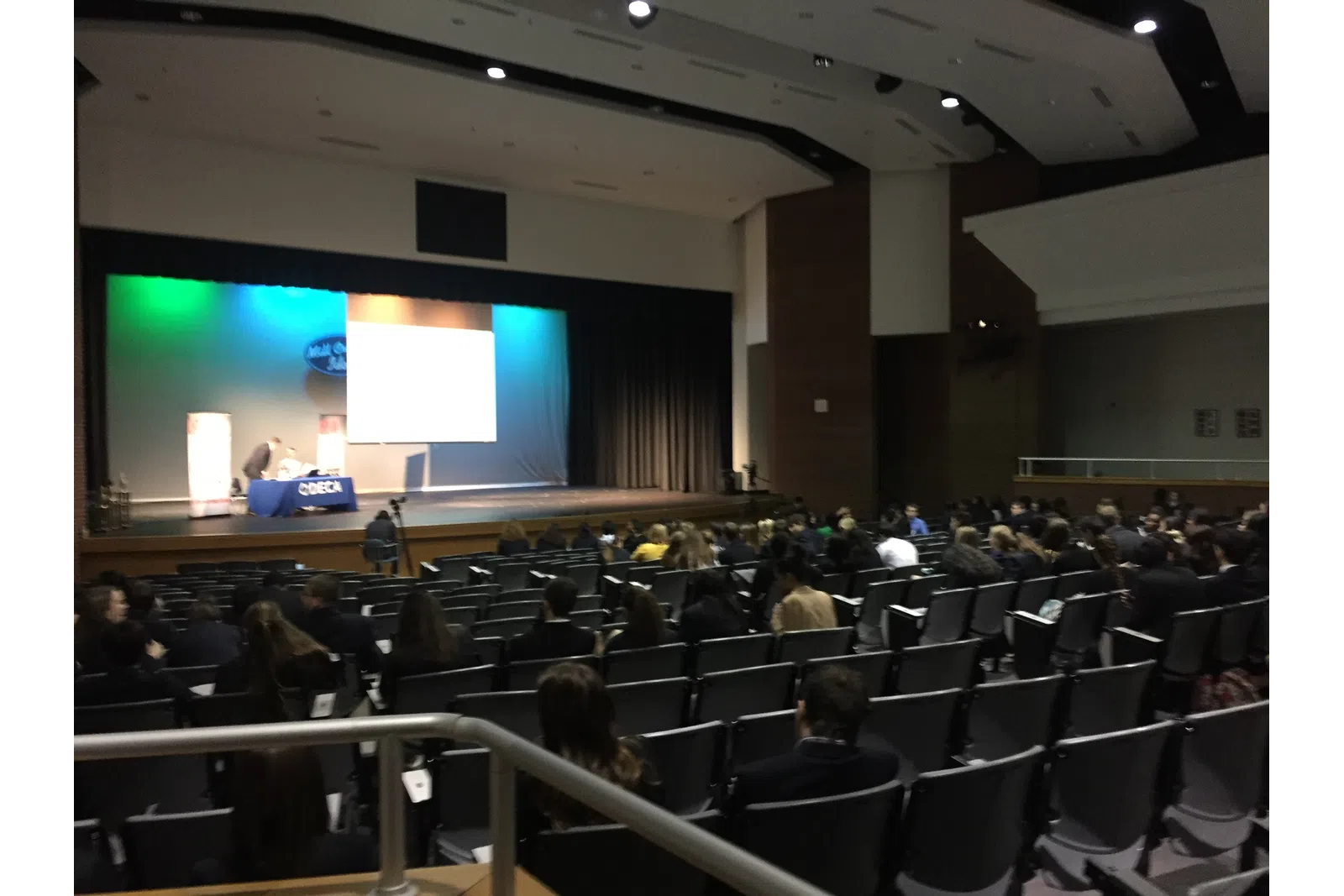 a group of people sitting in a room with a large screen