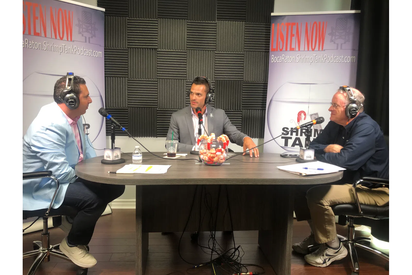 a group of men sitting at a table with microphones