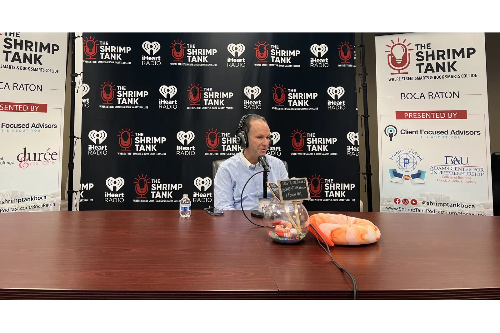 a person wearing headphones and sitting at a table with a microphone
