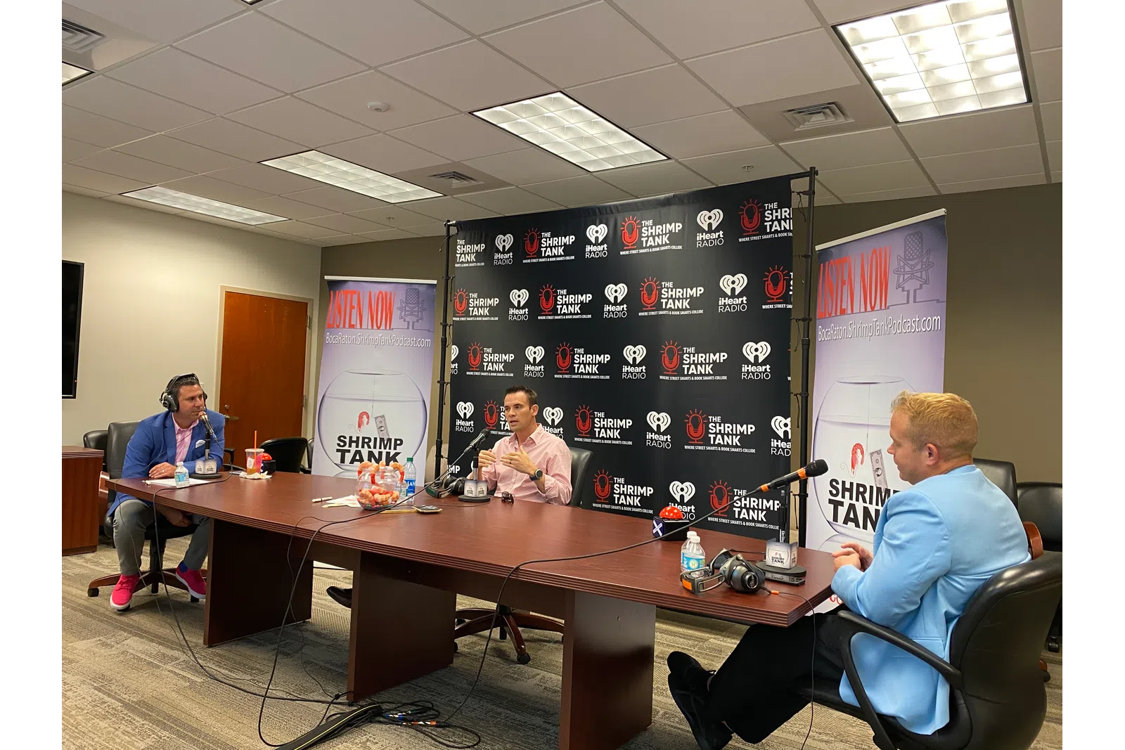 a group of people sitting around a table with microphones