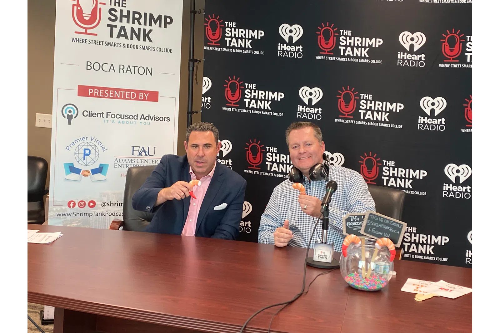 a couple of men sitting at a table with microphones
