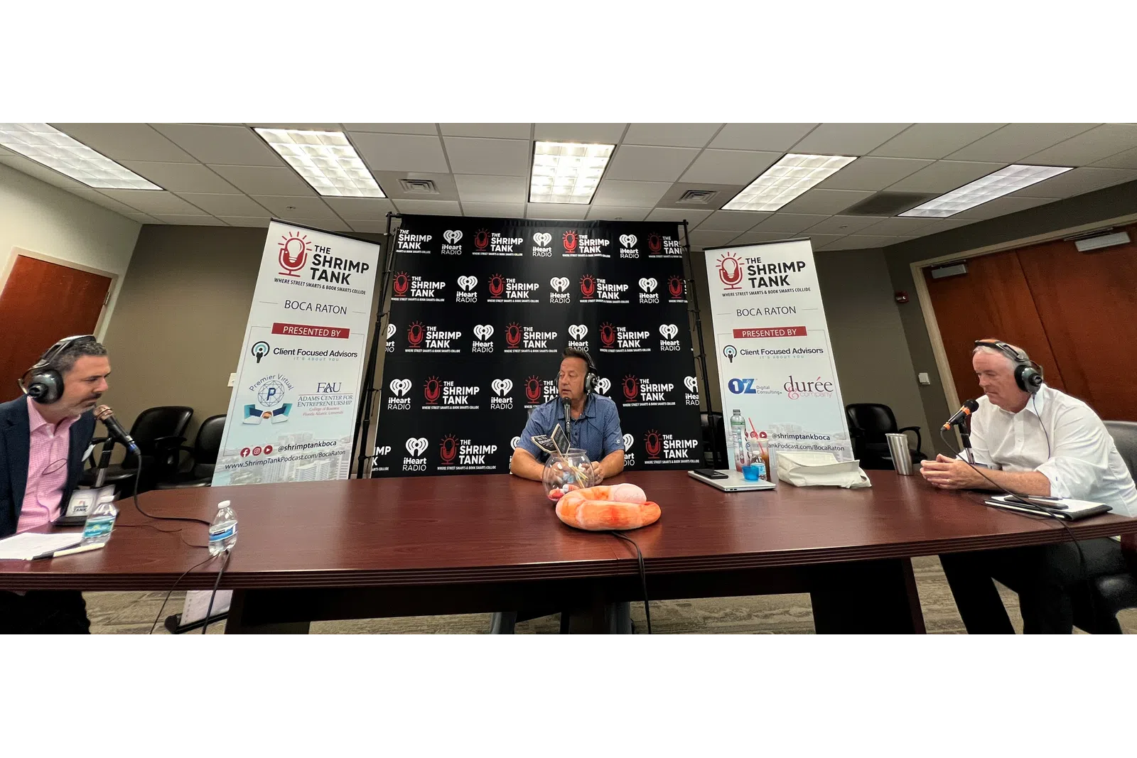 a group of people sitting at a table with microphones