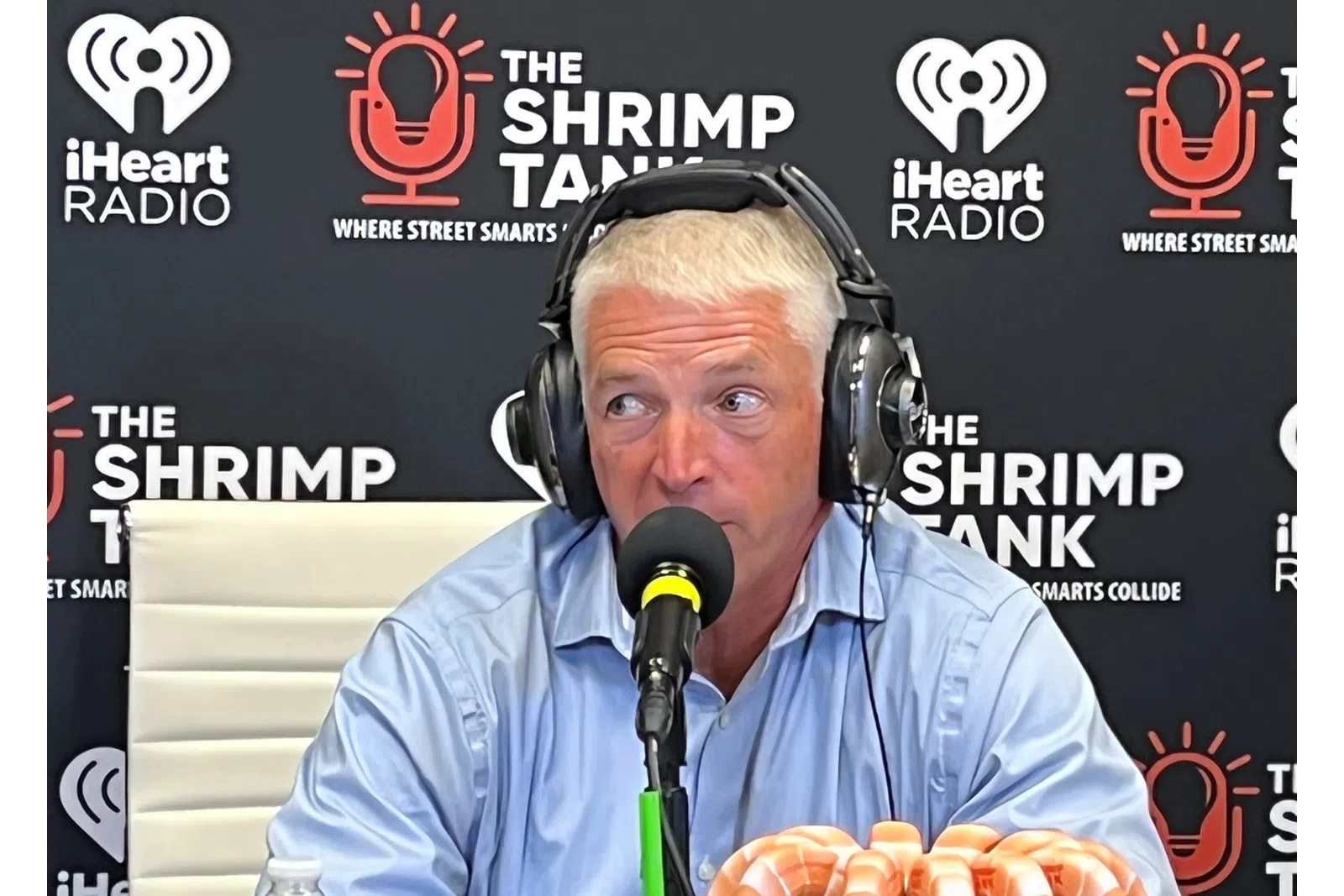 a man wearing headphones and sitting at a microphone