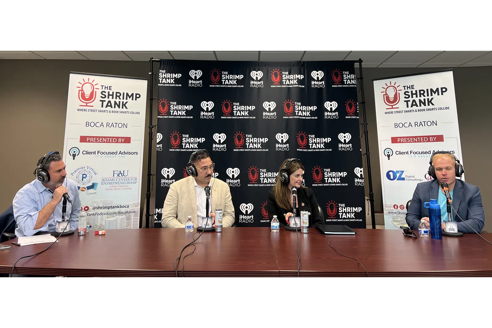 a group of people sitting at a table with microphones