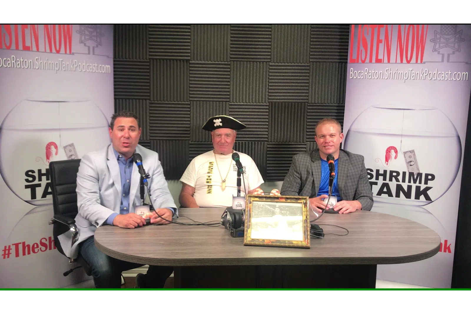 a group of men sitting at a table with a plaque