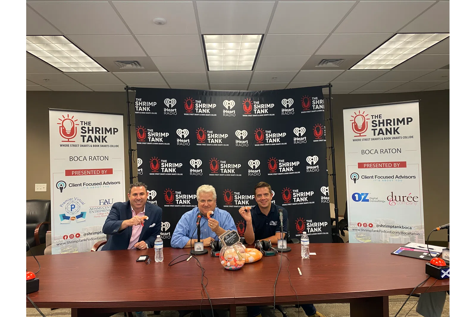a group of men sitting at a table with microphones and signs