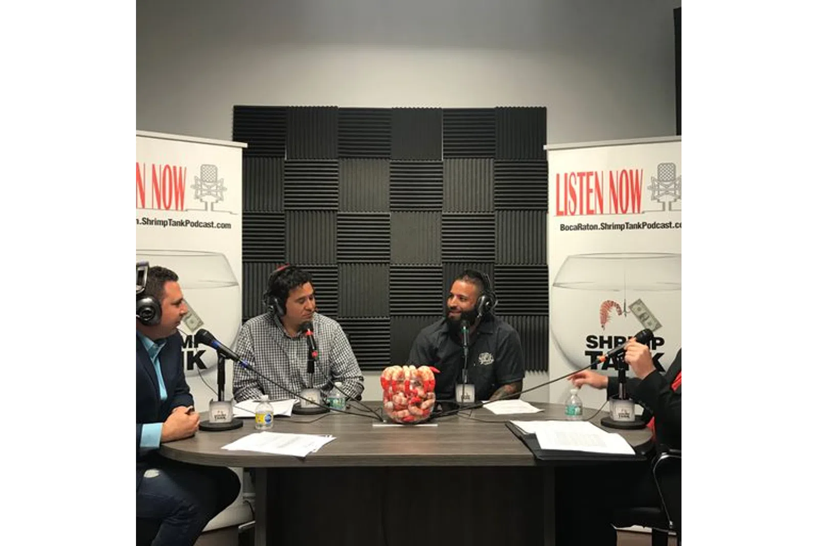a group of people sitting at a table with microphones
