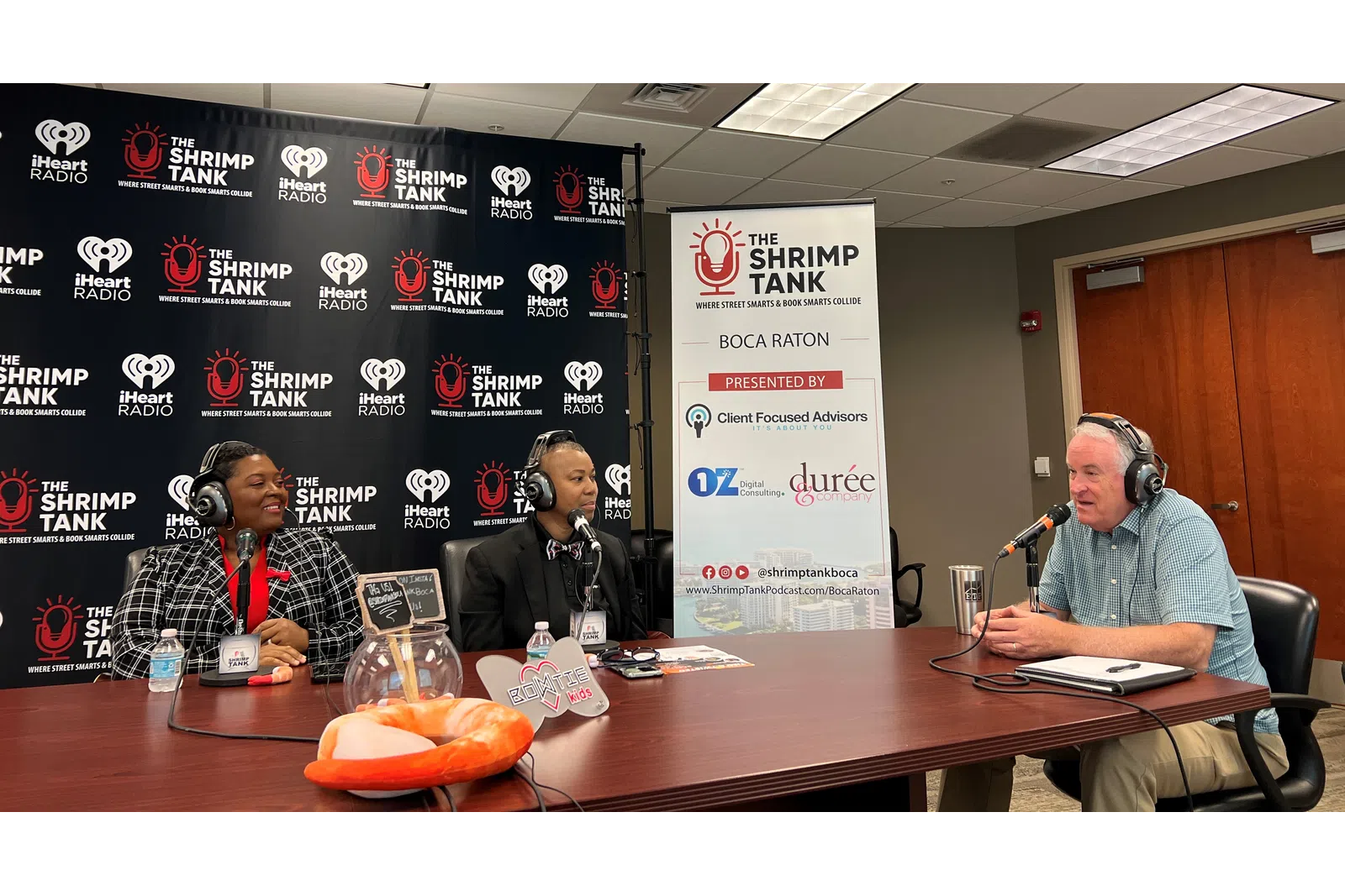 a group of people sitting at a table with microphones