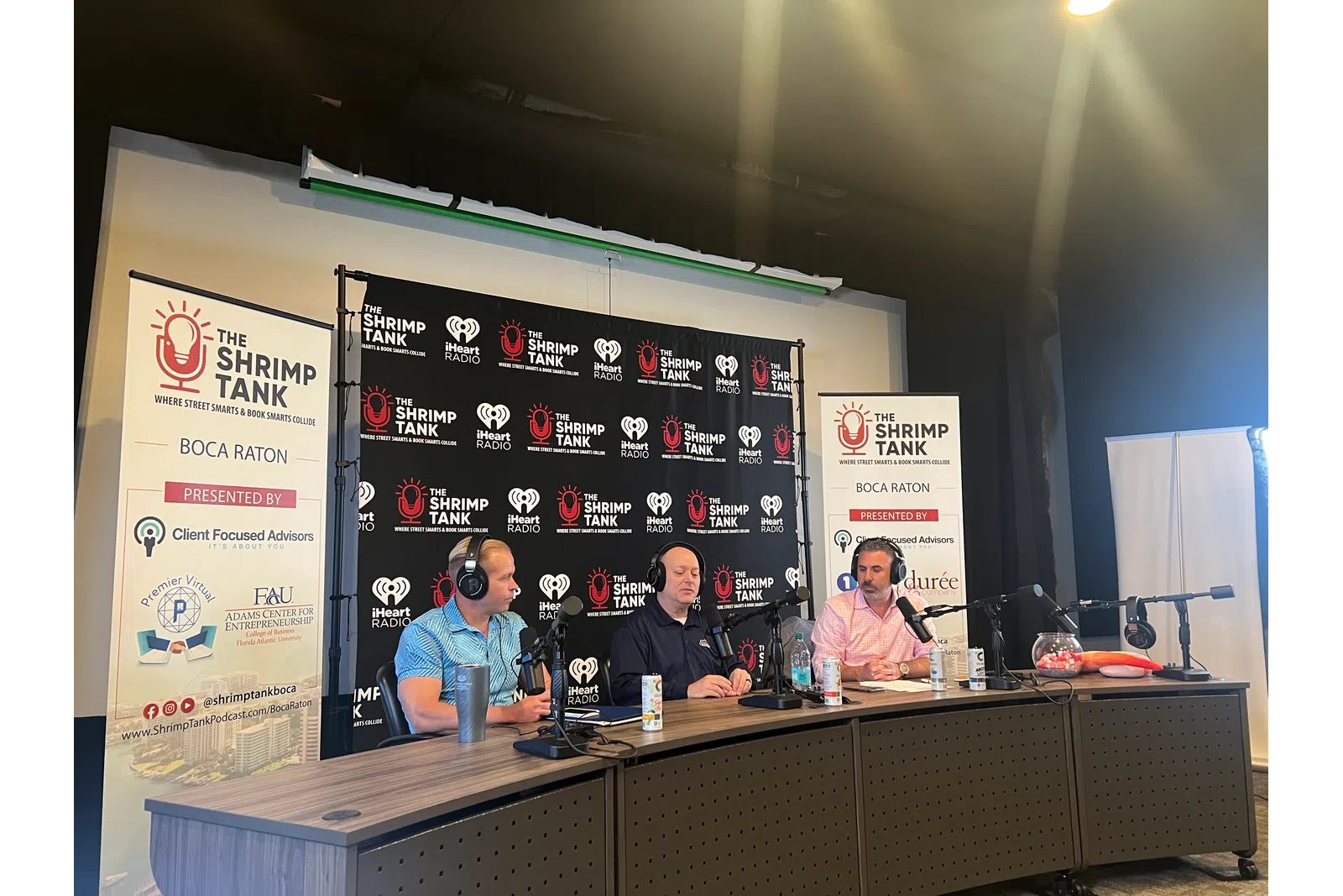 a group of people sitting at a table with microphones