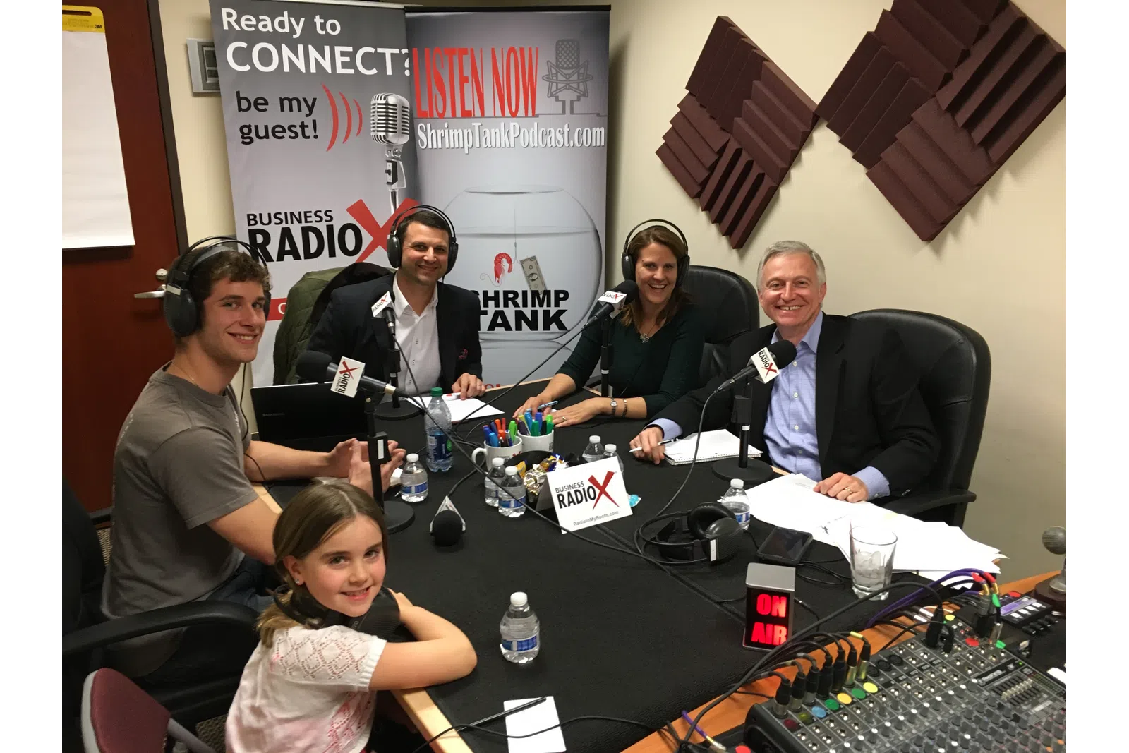 a group of people sitting around a table with microphones