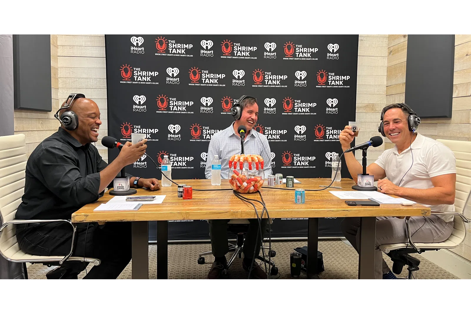 a group of men sitting at a table with microphones