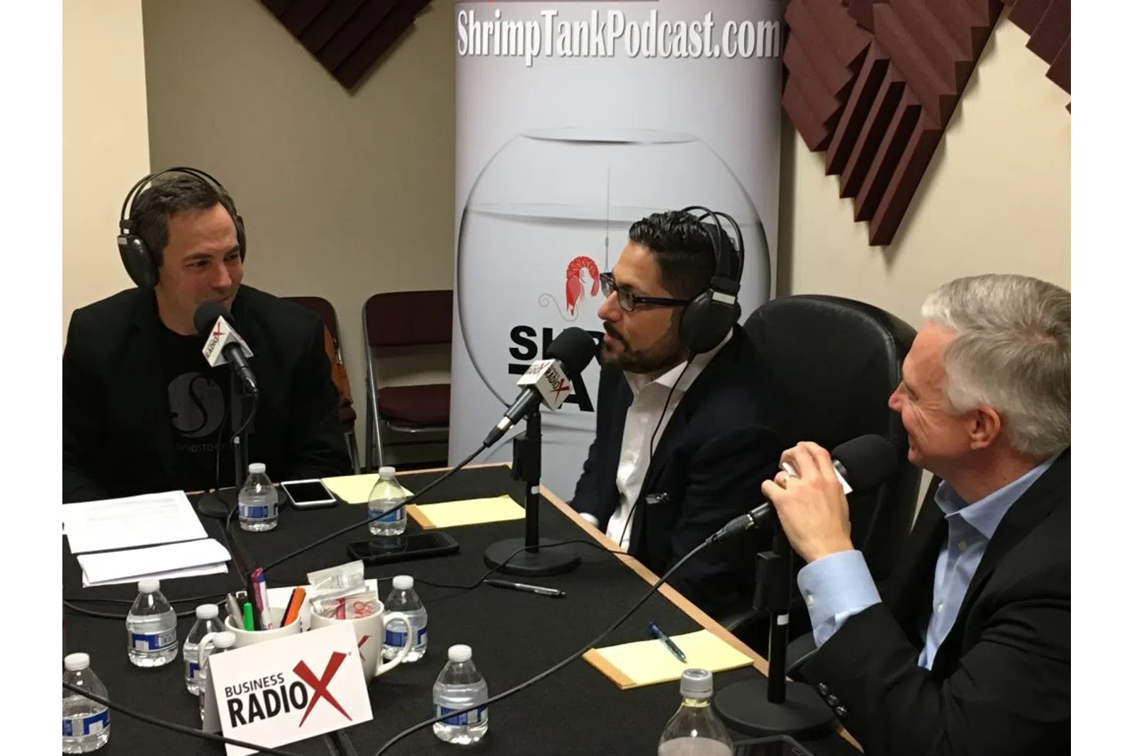 a group of men sitting at a table with microphones