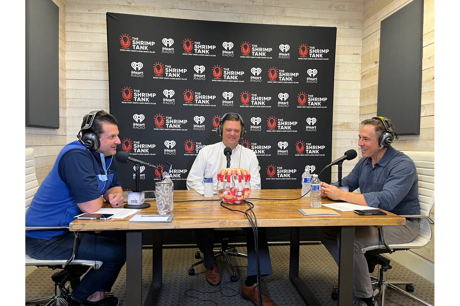 a group of people sitting at a table with microphones