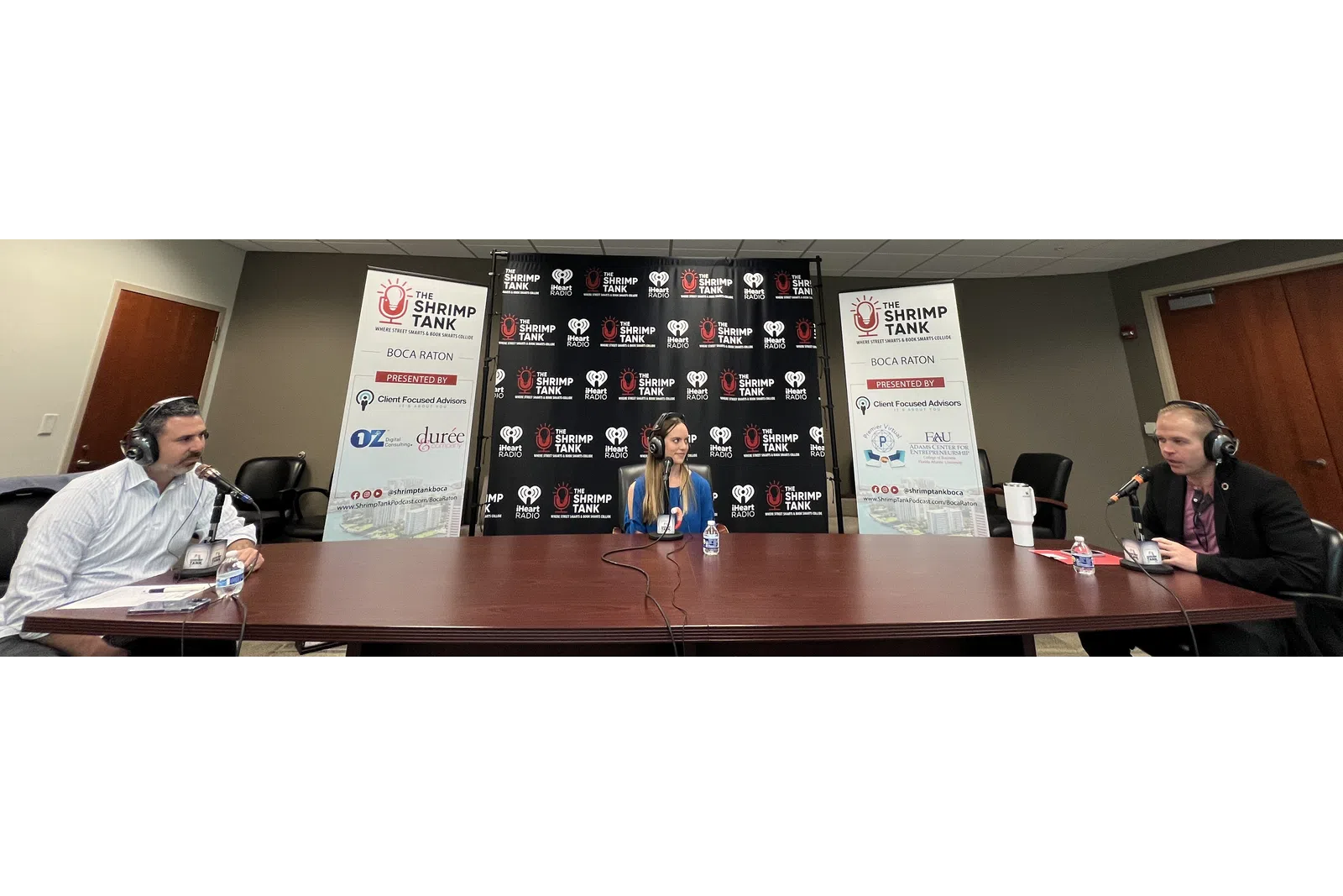 a group of people sitting at a table with microphones