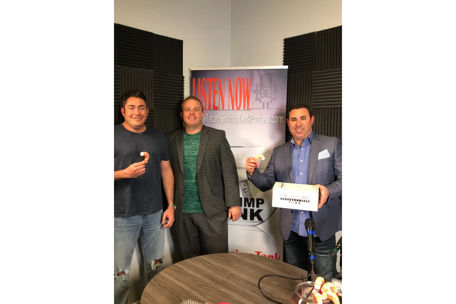 a group of men standing in a room with a sign
