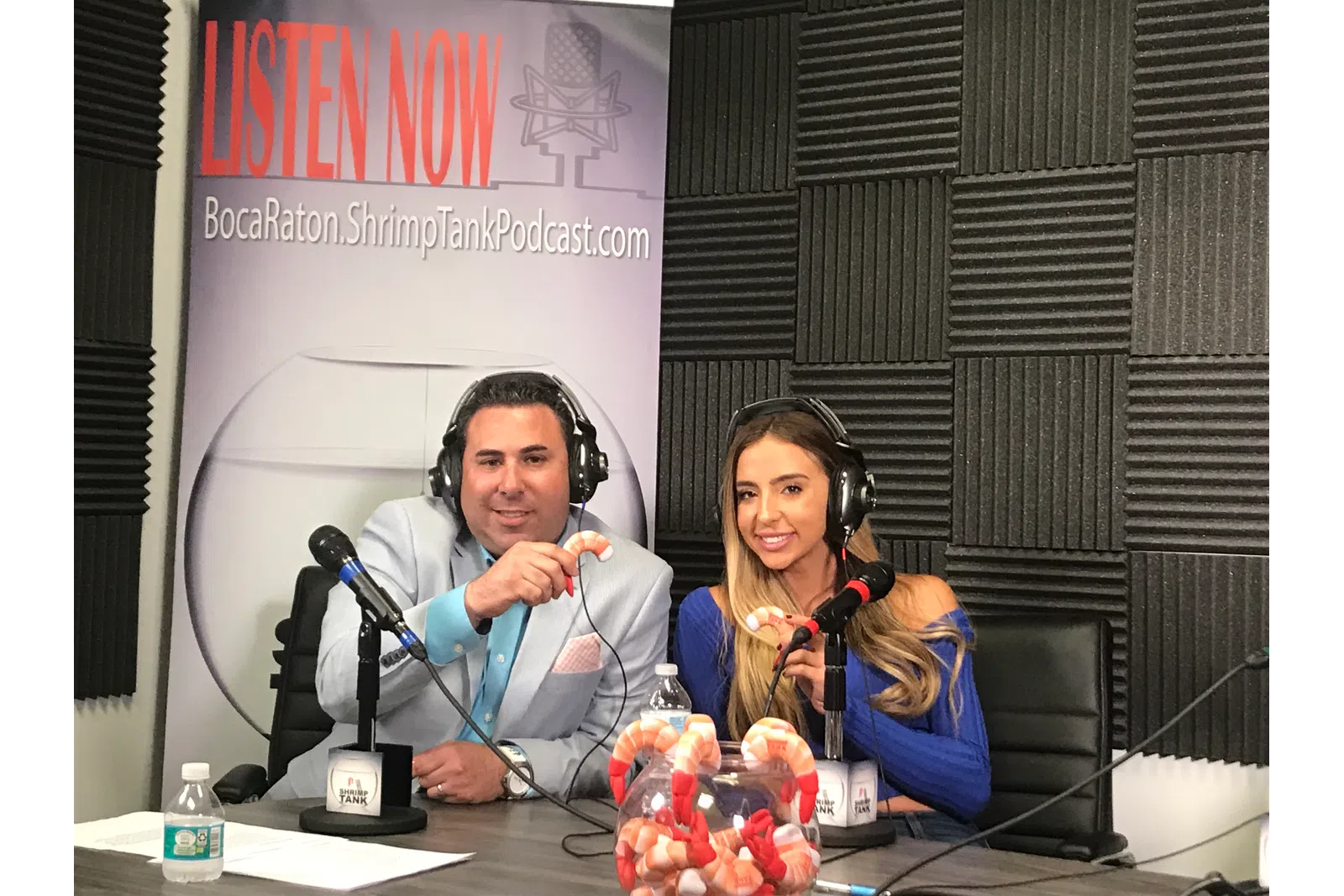 a group of people sitting at a table with microphones