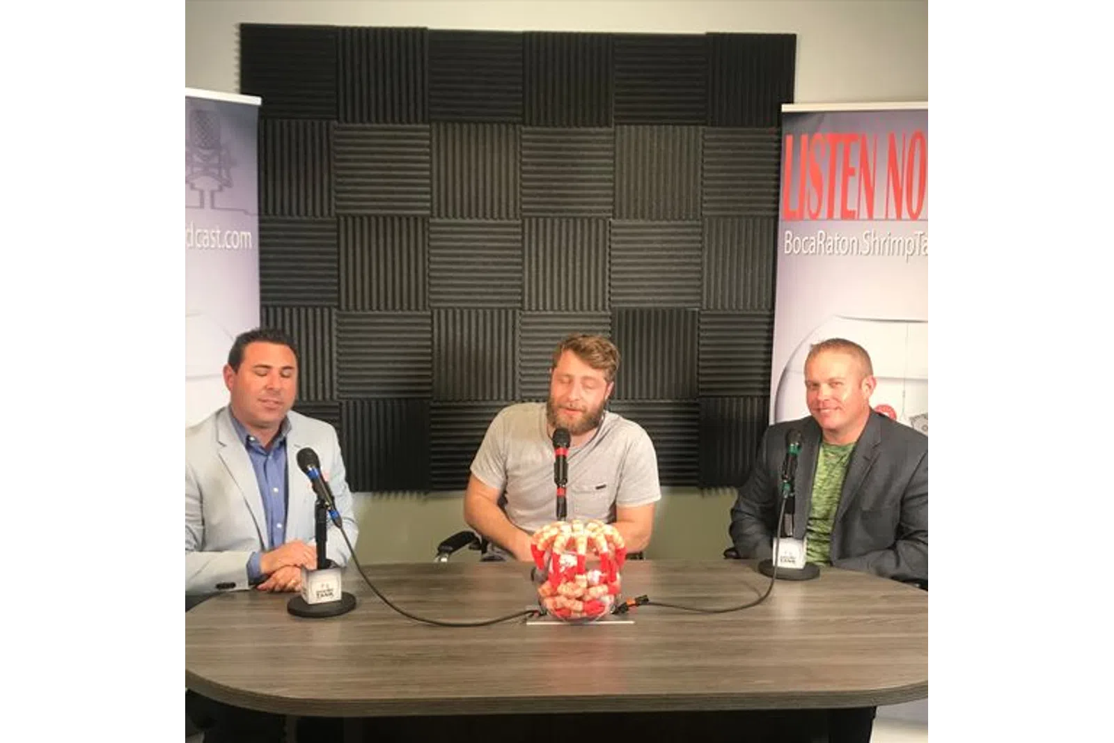 a group of men sitting at a table with microphones
