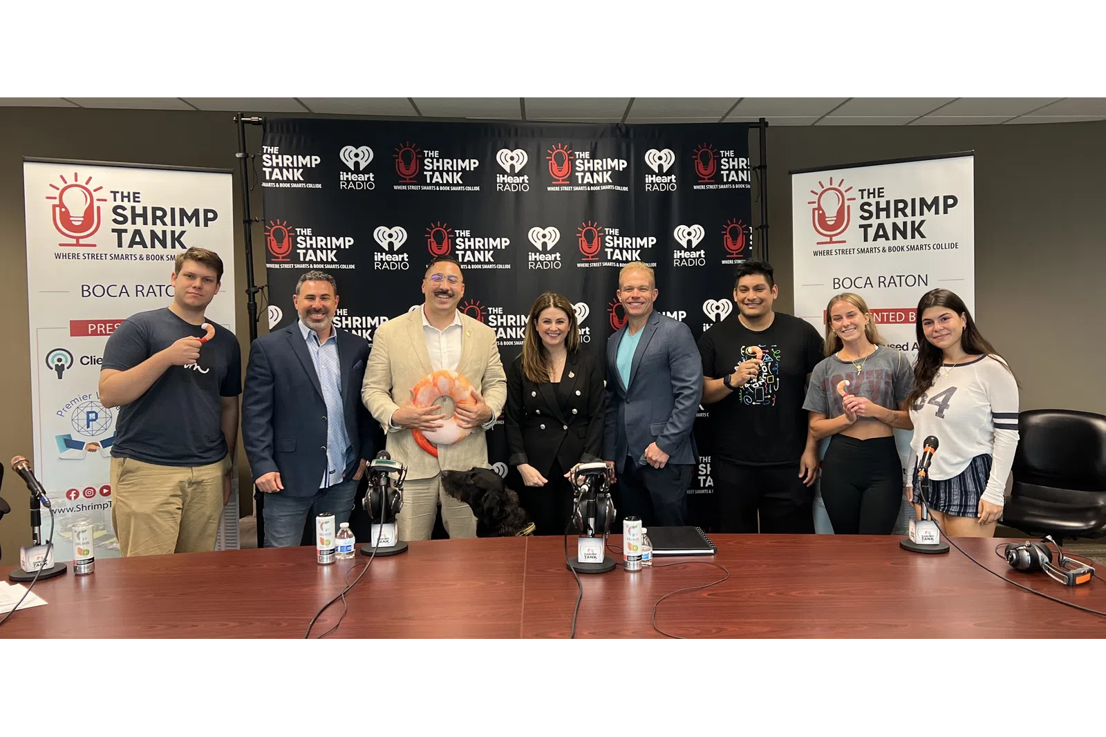 a group of people standing around a table with trophies